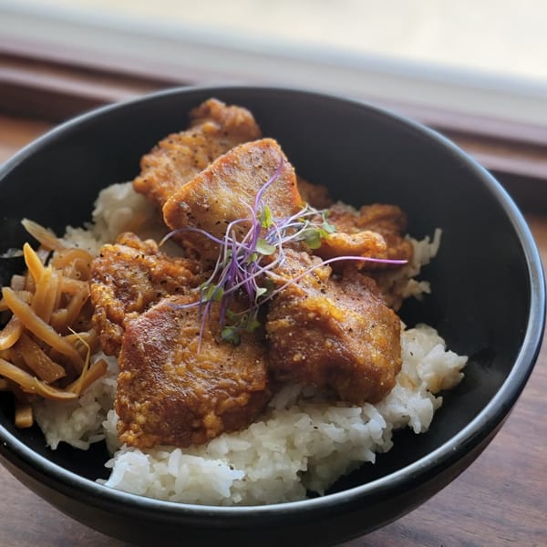 Miyo's Japanese fried chicken and rice bowl, garnished with pickled ginger and microgreens.